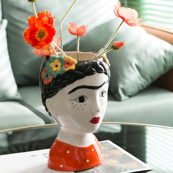 Handmade ceramic doll vase displayed with fresh flowers"