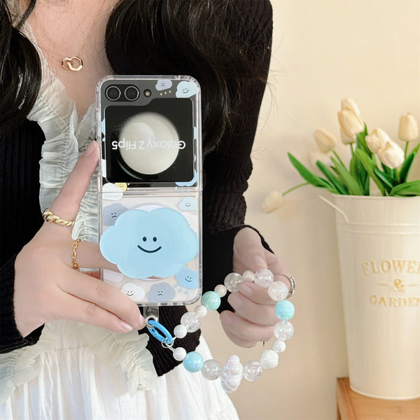 Close-up of a cute cloud phone case with a beaded strap in pastel colors, held by a woman