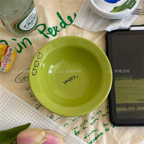 Set of happy ceramic bowls and cups with cheerful designs and vibrant colors