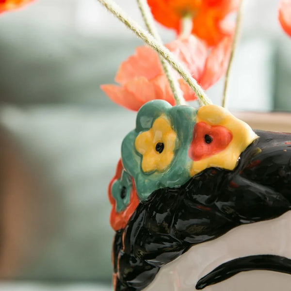 Hand-painted ceramic doll vase with floral design"