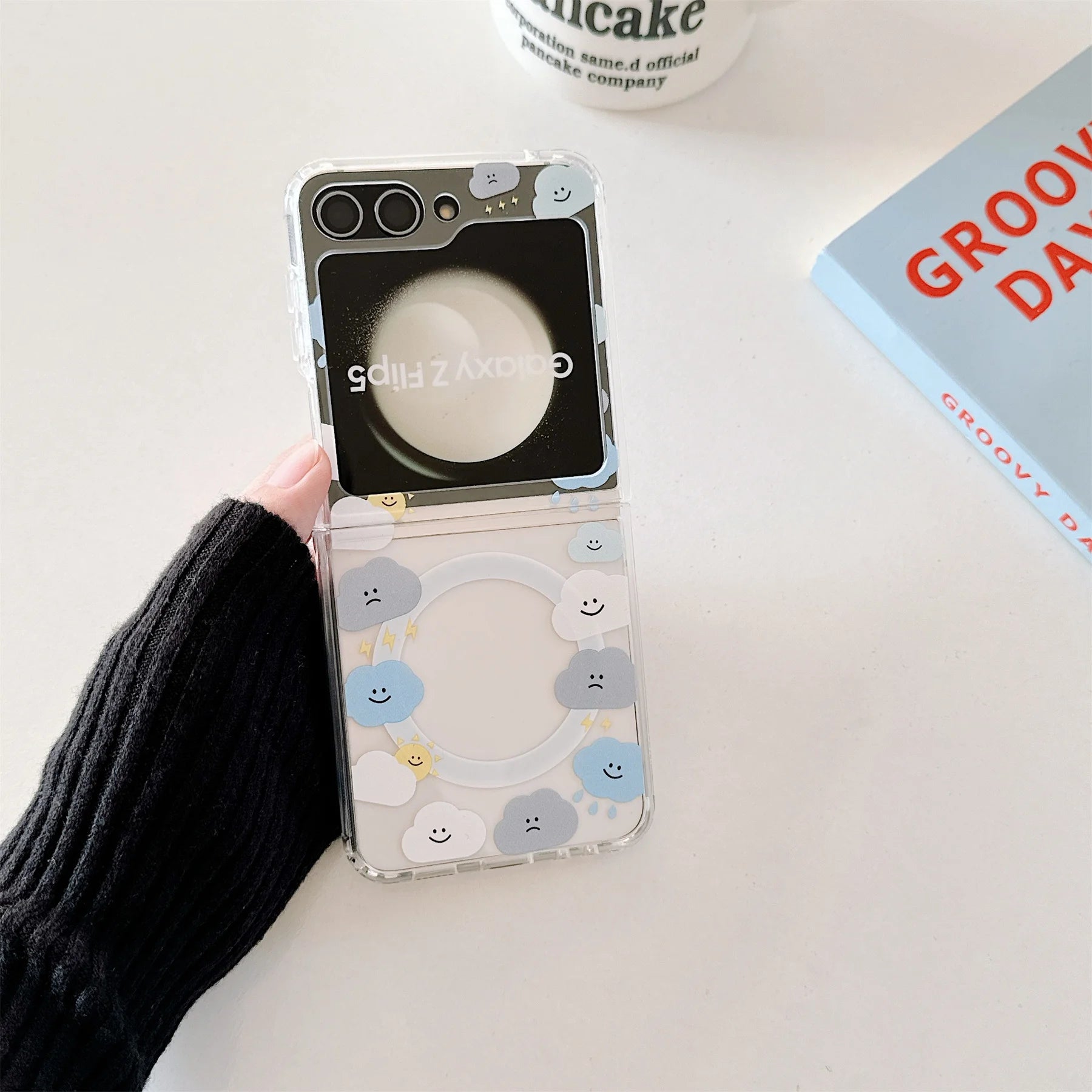 Close-up of a cute cloud phone case with a beaded strap in pastel colors, held by a woman